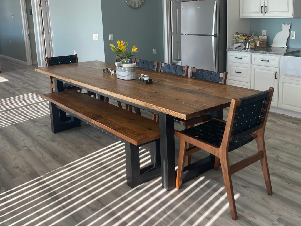 A sleek blend of industrial form and natural finish, the Flagler Modern Table brings warmth and edge to your space with bold black legs and a richly grained wood top.