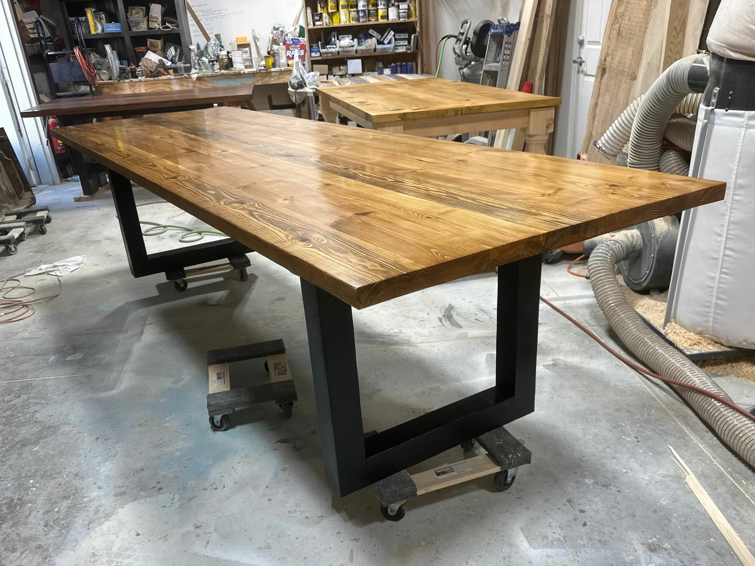 A sleek blend of industrial form and natural finish, the Flagler Modern Table brings warmth and edge to your space with bold black legs and a richly grained wood top.